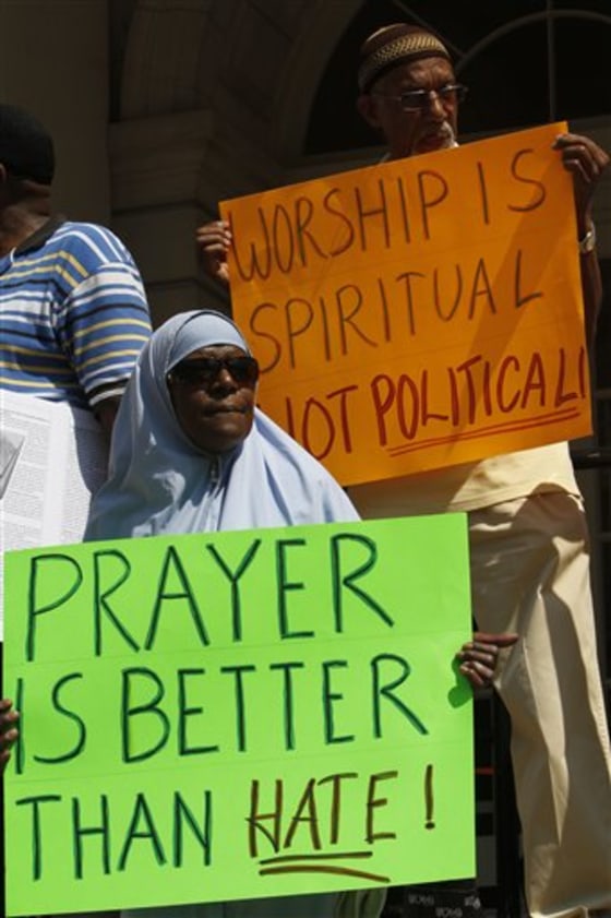 Demonstrators hold up signs during a news conference on the step of New York's City Hall on Wednesday.